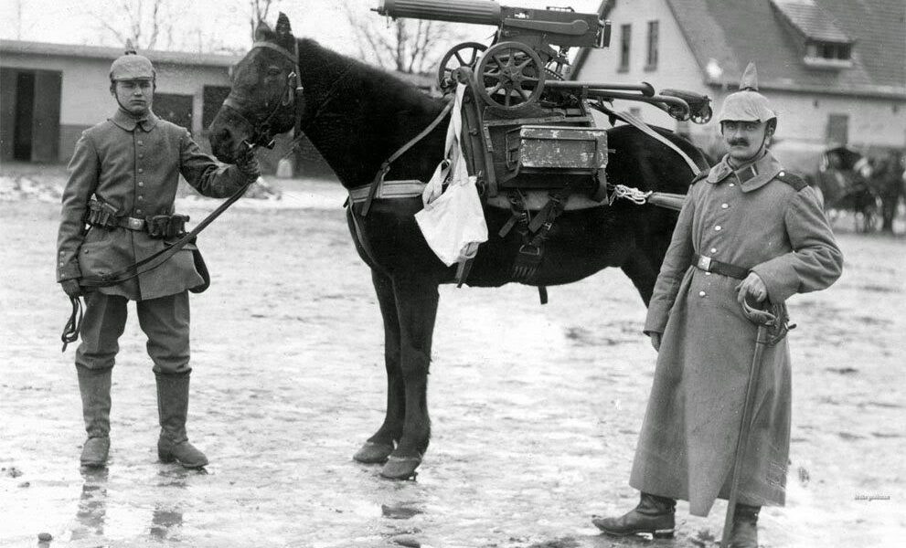 Deutsche Soldaten posieren während des Ersten Weltkriegs mit einem Pferd, auf dem ein erbeutetes Maschinengewehr sitzt