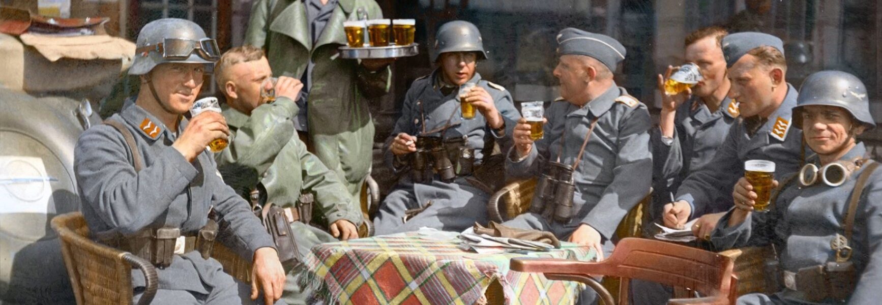 Eine Gruppe von Soldaten des deutschen Nachrichtenkorps der Luftwaffe (Kradmelder) gönnt sich ein Bier auf einer Terrasse in der verlassenen niederländischen Stadt Breda (Nordbrabant, Niederlande). Mai 1940