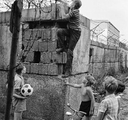 Emotionale Vintage-Fotos von spielenden Kindern an der Berliner Mauer im Jahr 1963.