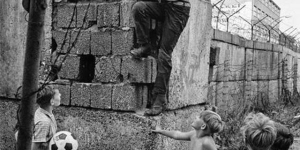 Emotionale Vintage-Fotos von spielenden Kindern an der Berliner Mauer im Jahr 1963.