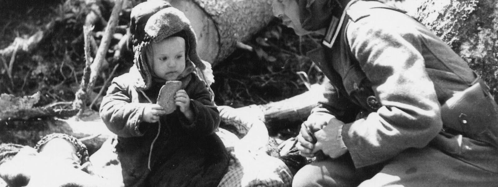 Deutscher Soldat gibt einem russischen Waisenjungen Brot, 1942