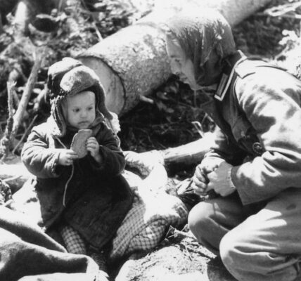 Deutscher Soldat gibt einem russischen Waisenjungen Brot, 1942