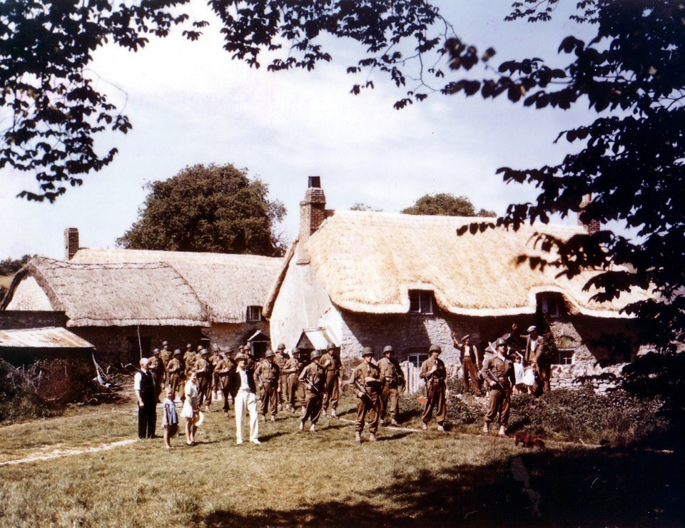 Eine Szene in einem niederländischen Dorf mit einer Windmuhle, deutschen Soldaten und Einheimischen.