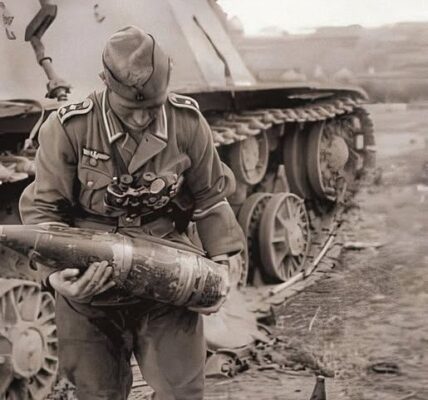 Ein deutscher Feldwebel betrachtet eine erbeutete 152-mm-Granate vor einem zerstörten sowjetischen SU-152 – Ostfront, 1943!