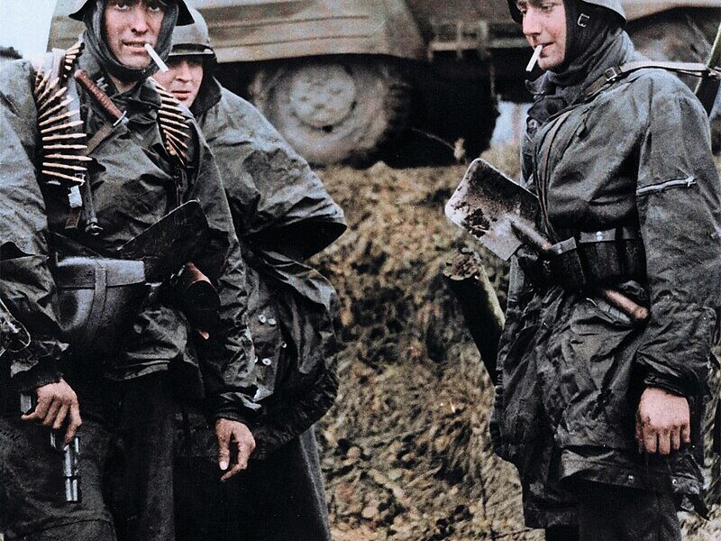 Deutsche MG42-MG-Besatzung passiert zerstörten Elefant-Panzerjäger in Nettuno, Italien, März 1944.