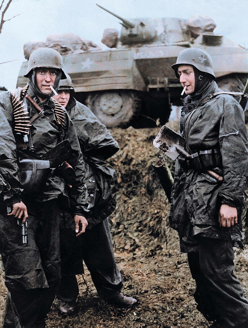Deutsche MG42-MG-Besatzung passiert zerstörten Elefant-Panzerjäger in Nettuno, Italien, März 1944.