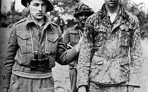 Kanadischer Soldat mit geschlagenem deutschen Kriegsgefangenen, Caen, 1944