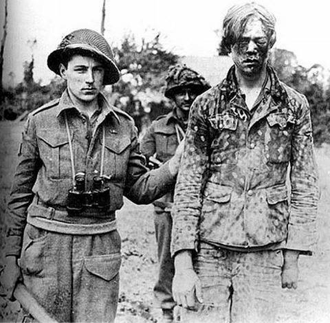Kanadischer Soldat mit geschlagenem deutschen Kriegsgefangenen, Caen, 1944