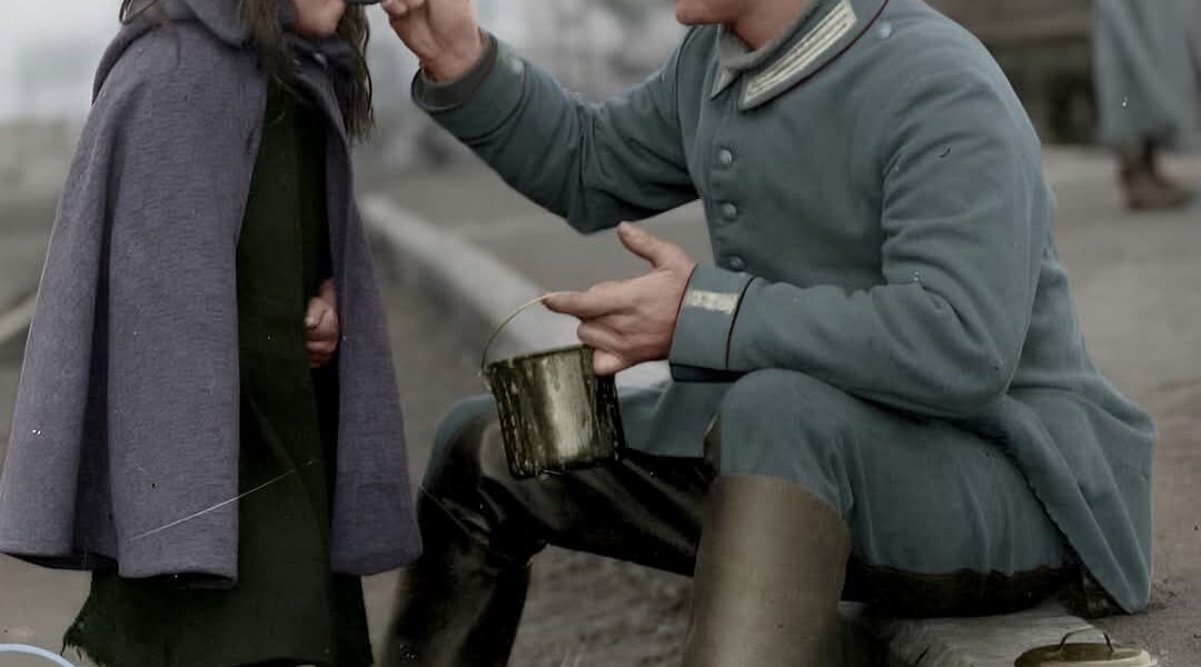 Ein Moment der Menschlichkeit: Deutscher Soldat teilt 1915 sein Essen mit belgischem Kind.