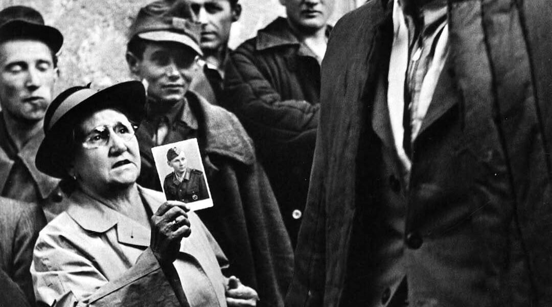 Eine Mutter zeigt einem heimkehrenden Kriegsgefangenen ein Bild ihres Sohnes, 1947