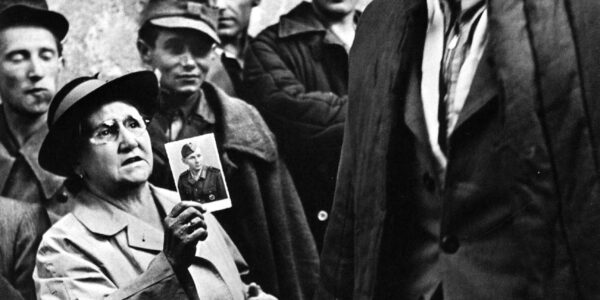 Eine Mutter zeigt einem heimkehrenden Kriegsgefangenen ein Bild ihres Sohnes, 1947