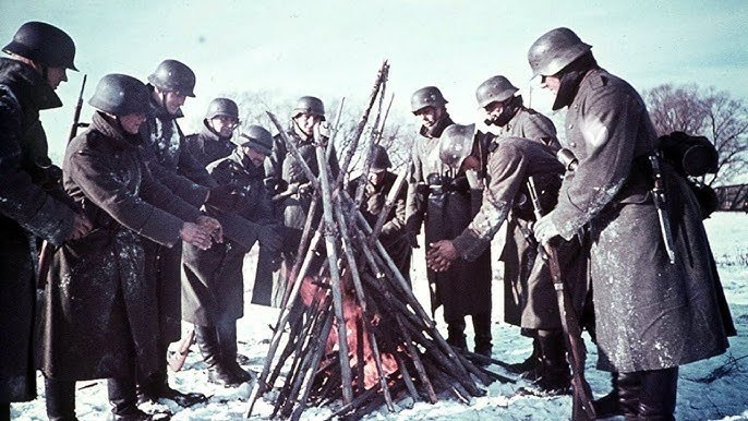 Winter an der Ostfront: Deutsche Soldaten wärmen sich an einem Lagerfeuer (1942).