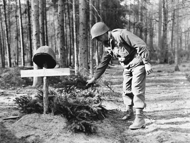 Ein stiller Gruß im Wald: Ein amerikanischer Soldat ehrt einen gefallenen deutschen Gegner